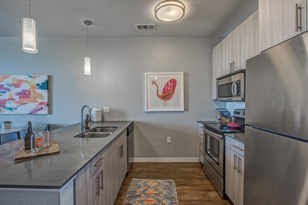 full kitchen with stainless steel appliances and counter tops at the flats at obsidian
