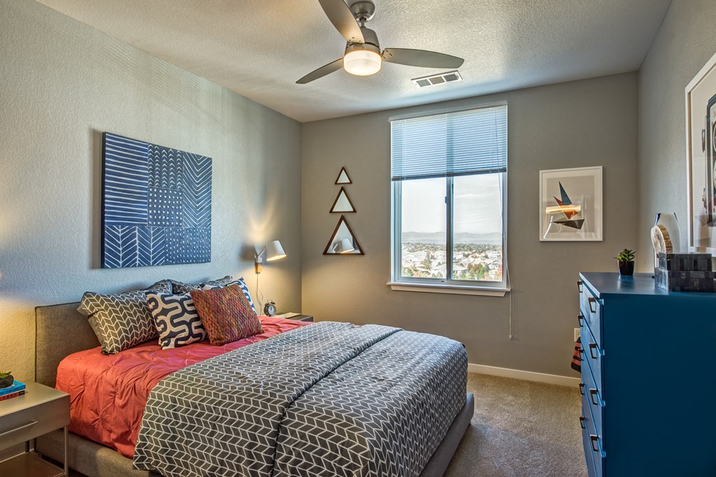 a bedroom with a bed and a ceiling fan