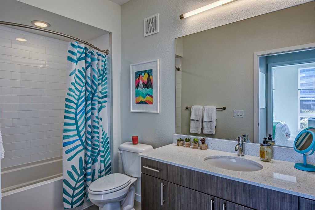 a bathroom with a shower and a sink and a toilet