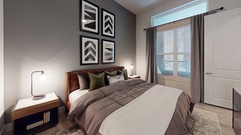 A bedroom with a large bed and a lamp on a side table.