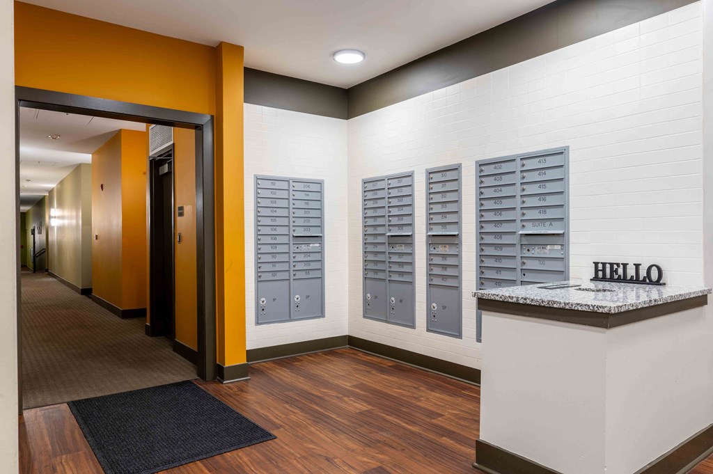 a lobby with lockers and a counter in front of a hallway with elevators