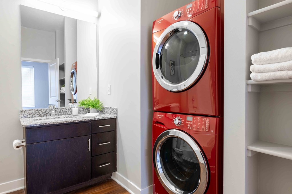 a washer and dryer in a bathroom with a sink