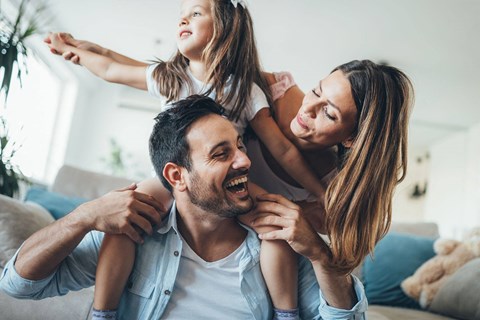 a man and woman sitting on a couch with a little girl