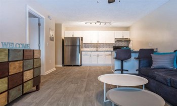 large kitchen with white cabinets and stainless steel appliances set against stone counter tops with eat-at bar and white subway tile backsplash - Photo Gallery 4
