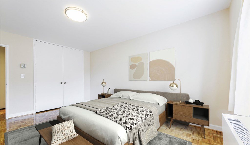 A bedroom with a large bed and a nightstand with a lamp.