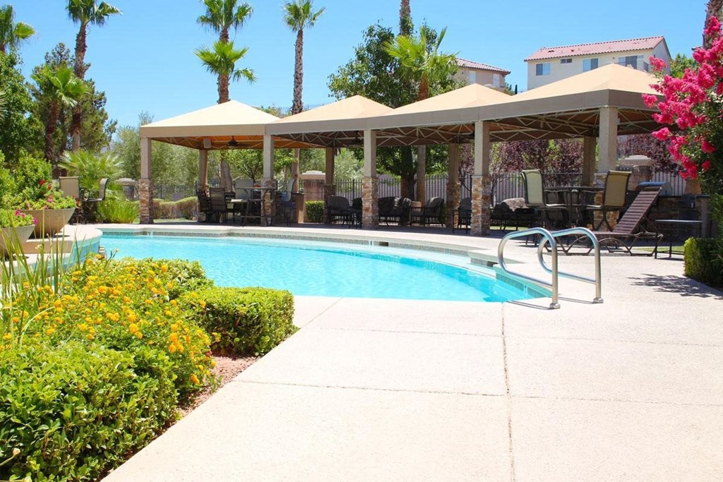 a swimming pool with chairs and umbrellas next to a resort pool
