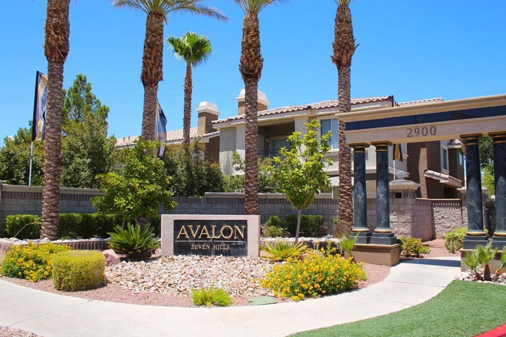 a sign in front of a building with palm trees