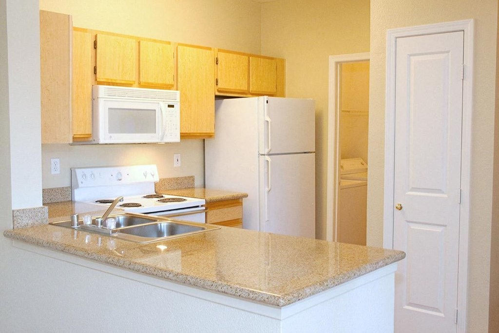 a kitchen with white appliances and a granite counter top