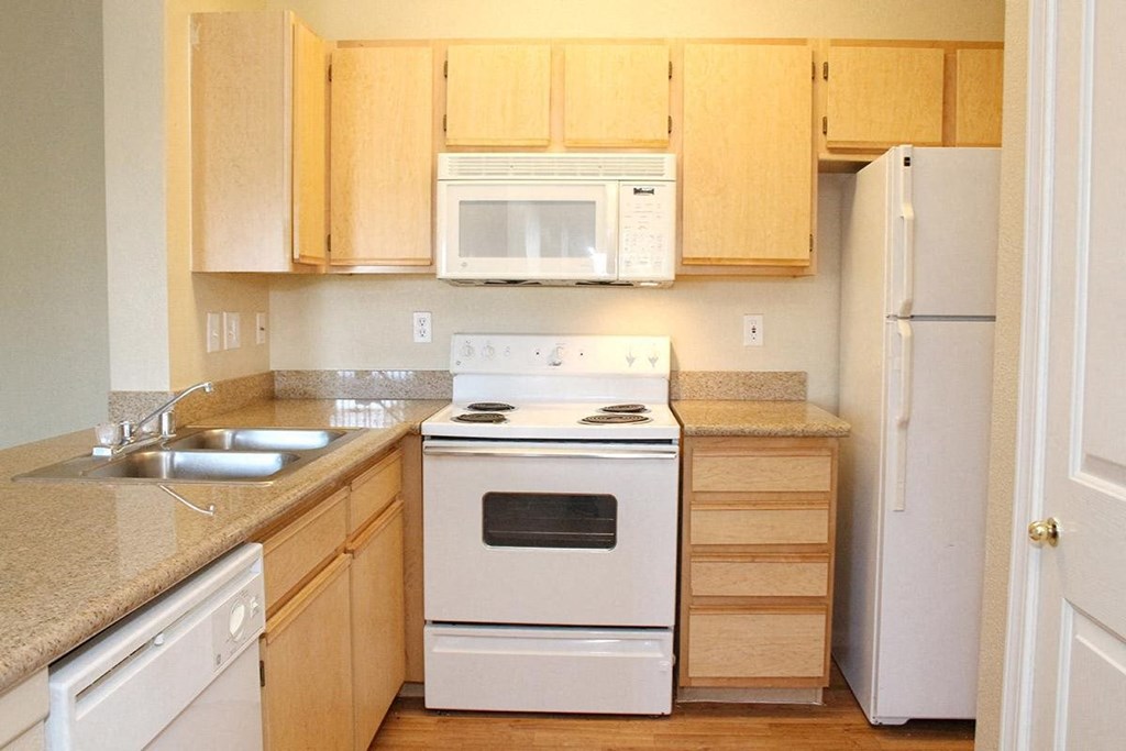a kitchen with white appliances and wooden cabinets