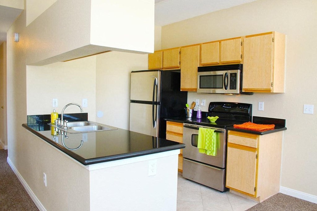 a kitchen with stainless steel appliances and a black counter top