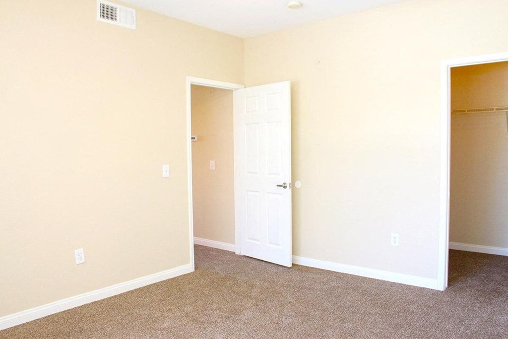 an empty room with a closet and an open door