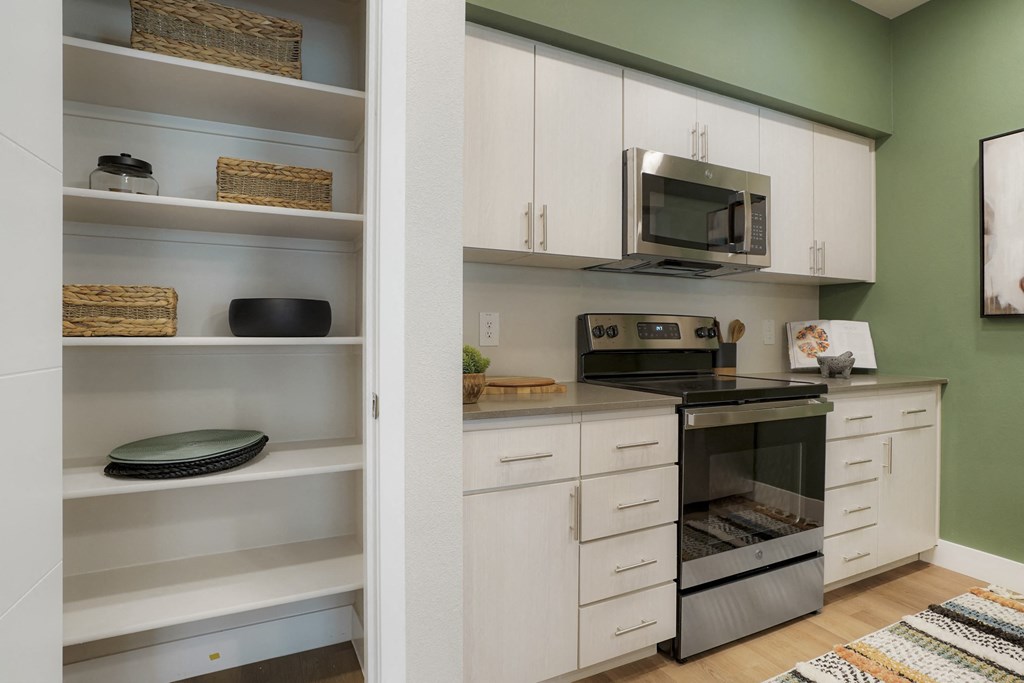 a kitchen with white cabinets and a black stove and a microwave