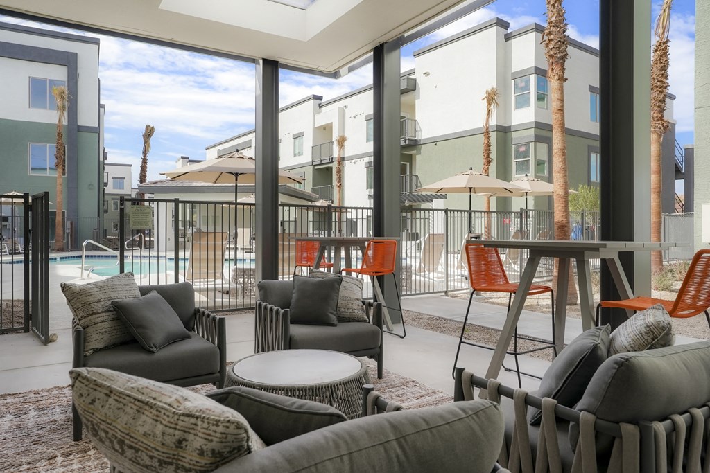 a living room with couches and chairs and a patio with a pool