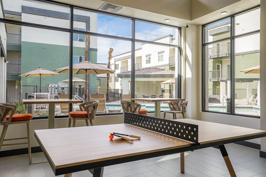 a table with a board game on it in a room with large windows