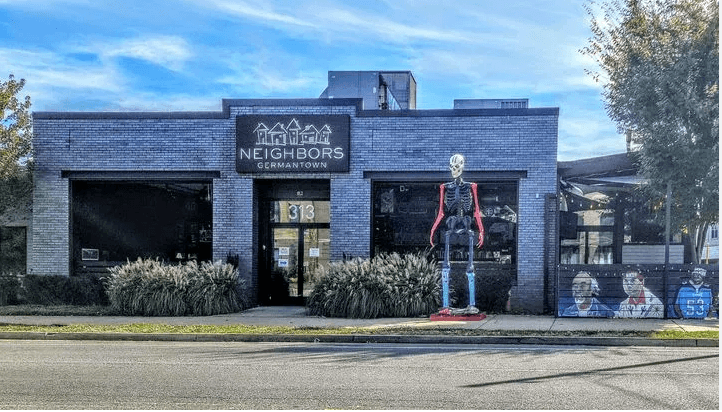 Exterior of Neighbors Germantown restaurant with a large skeleton decoration.
