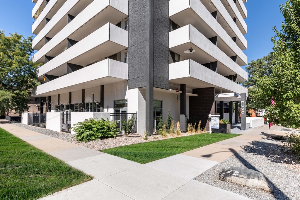 an office building with a sidewalk and grass in front of it