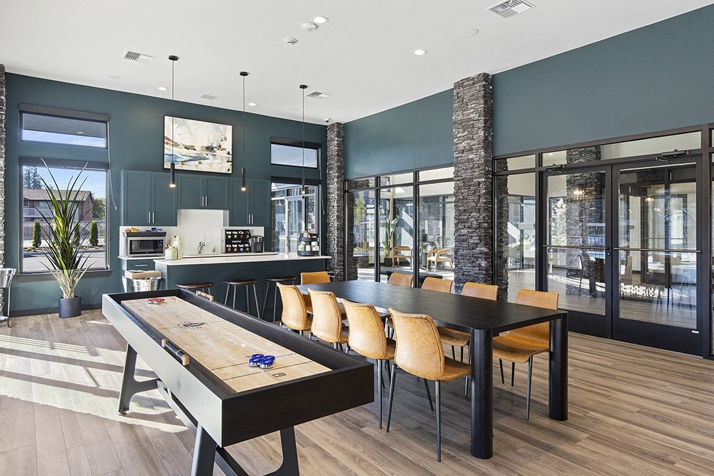 a game room with a foosball table and a long table with yellow chairs,