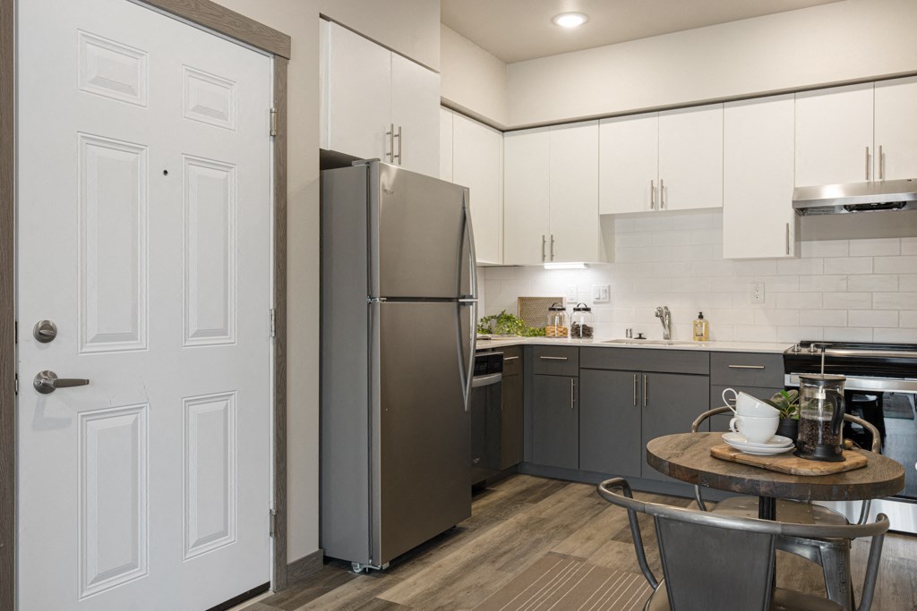 a kitchen with white cabinets and stainless steel appliances,