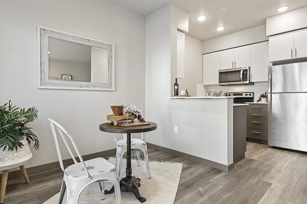 a kitchen and dining room with a table and chairs,