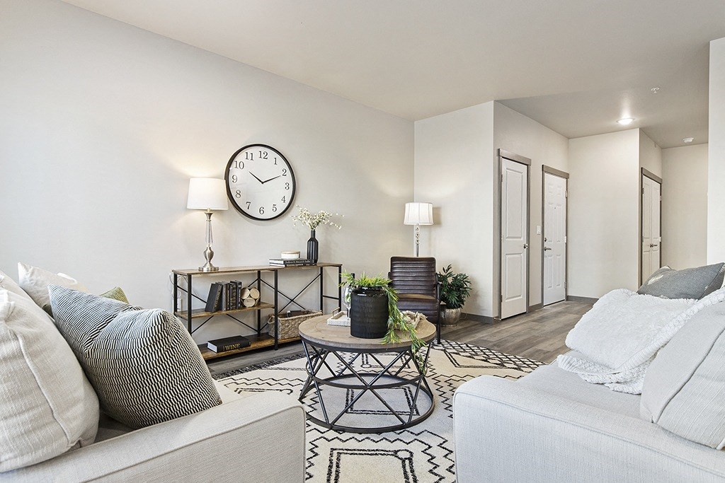 a spacious living room with white couches,