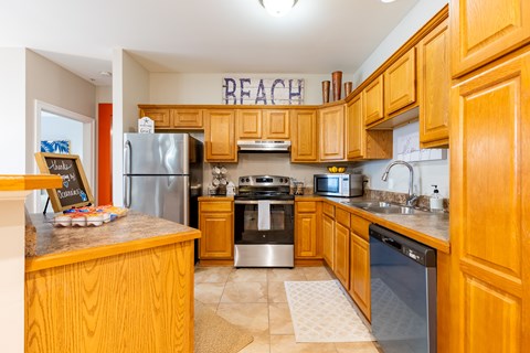 A kitchen with wooden cabinets and a sign that says Beach.