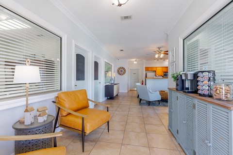 A living room with a yellow chair and a grey cabinet.