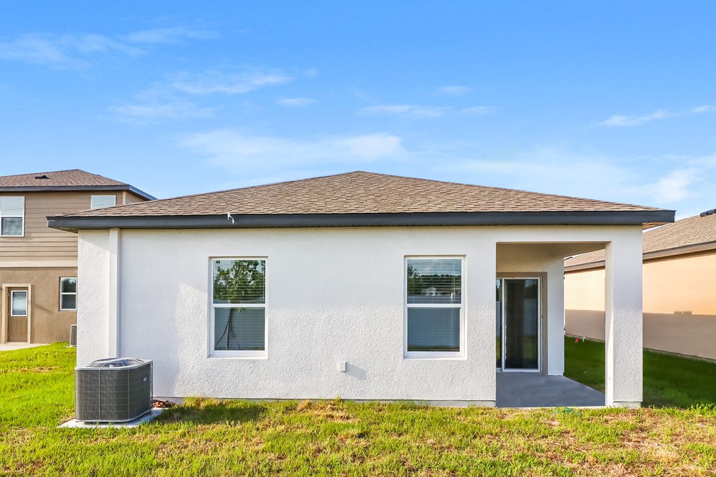 A white house with a brown roof and a grey door.