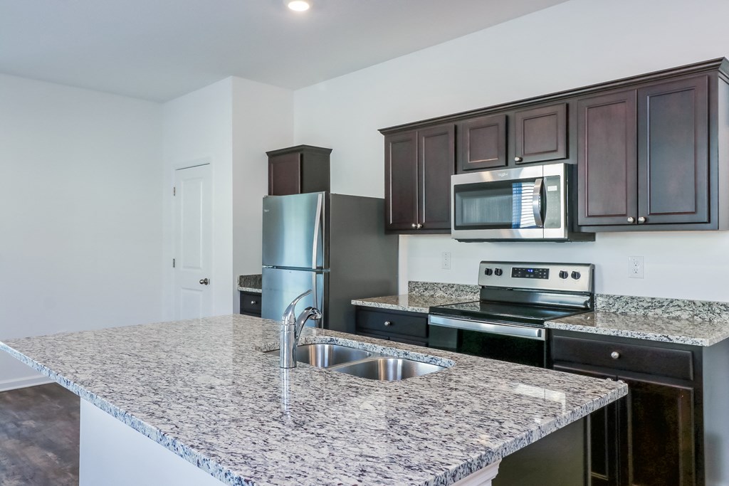 A kitchen with granite countertops and stainless steel appliances.
