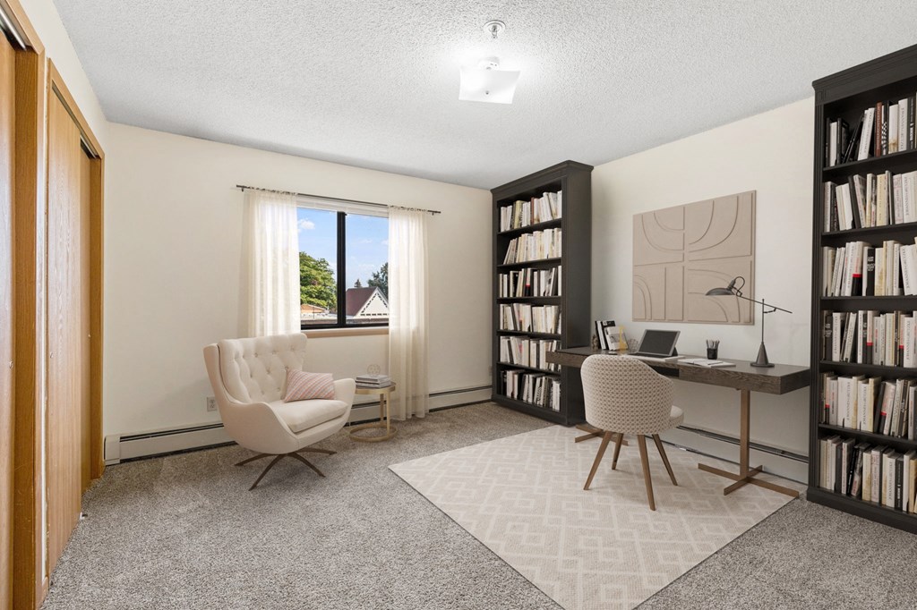 a home office with two chairs and a desk and a window
