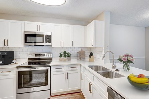 Atlanta, GA Apartments – One K Apartments – A kitchen with white cabinets and a stainless steel oven.
