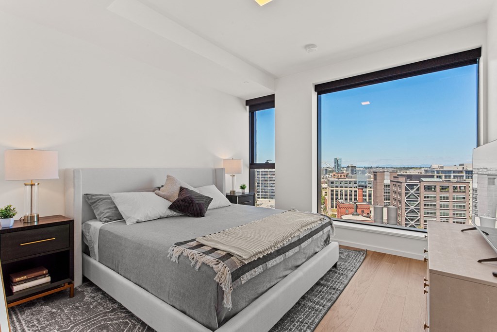 a bedroom with a large window and a large bed