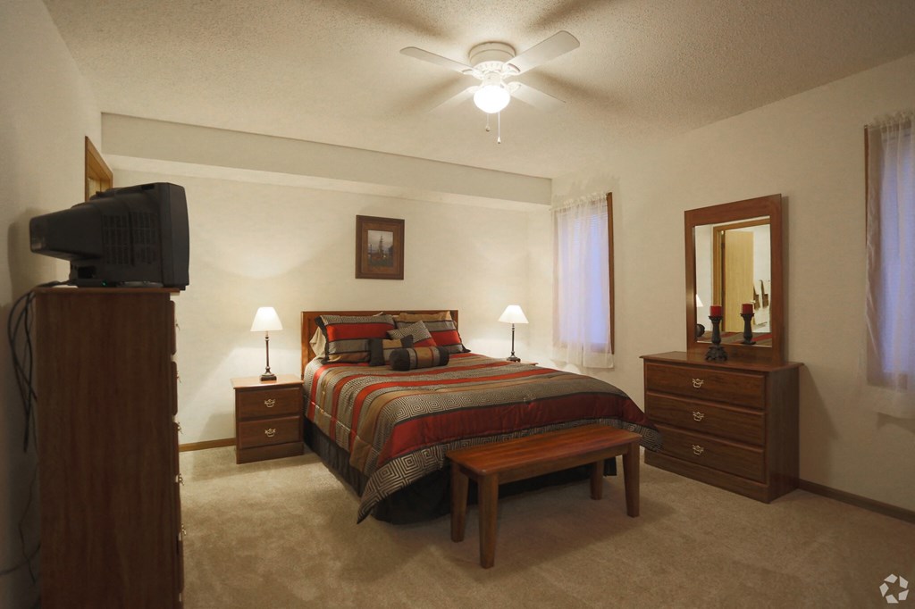a bedroom with a bed and a ceiling fan