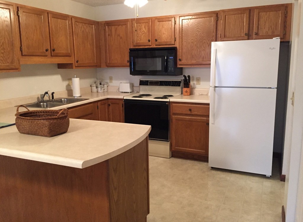 a kitchen with white appliances and wooden cabinets