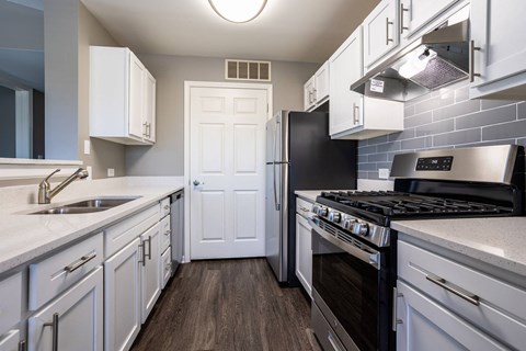 a kitchen with stainless steel appliances and white cabinets
