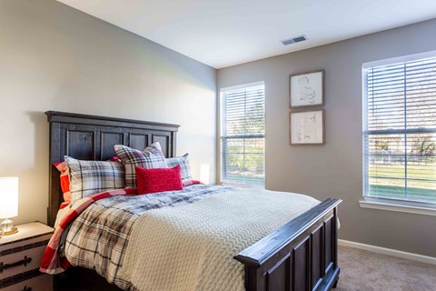 A bedroom with a bed, nightstand, and window.