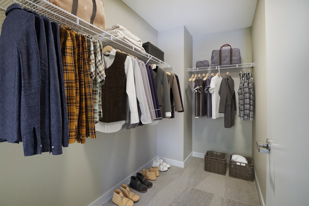 a walk in closet filled with clothes and shoes