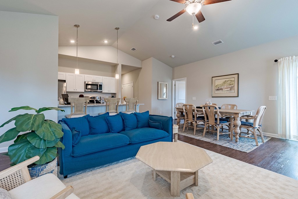 a living room with a blue couch and a dining room table