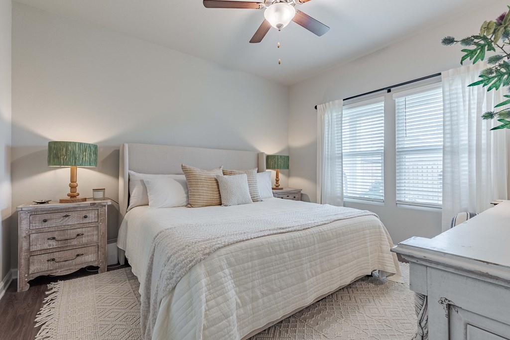 a bedroom with a large bed and a ceiling fan