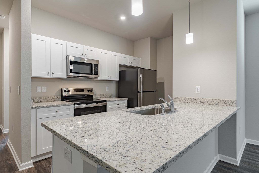 a kitchen with granite counter tops and a sink and a stove