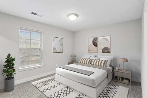 A bedroom with a large bed and a potted plant.