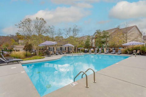 One, Two and Three- Bedroom Apartments for Rent in Sevierville, TN – Overlook at Allensville – A large swimming pool with seating areas and umbrellas