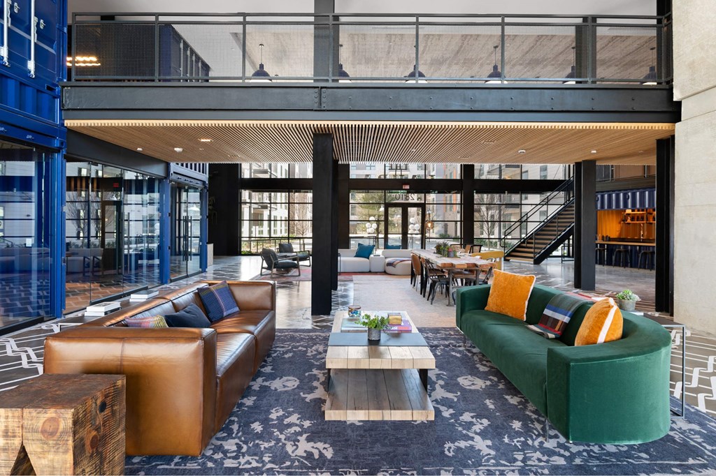 The community room insideThe Laura apartment complex in Houston, TX with long table and couches.