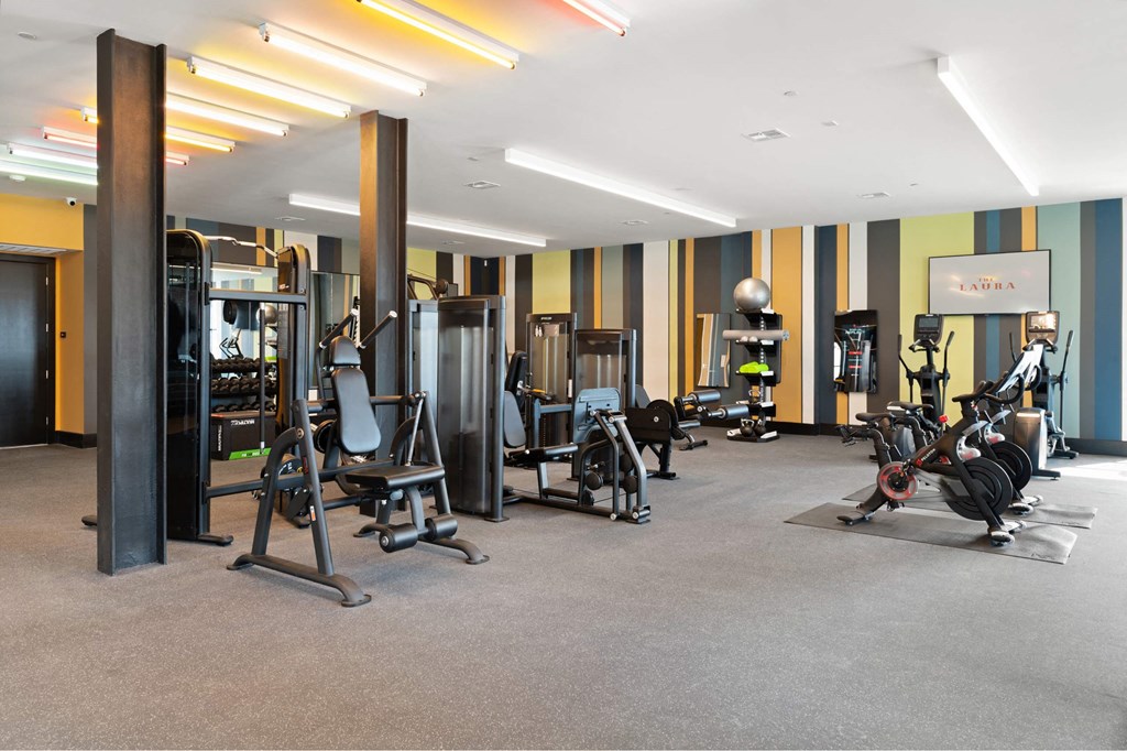 A gym with a variety of equipment including treadmills, weights, and exercise machines.