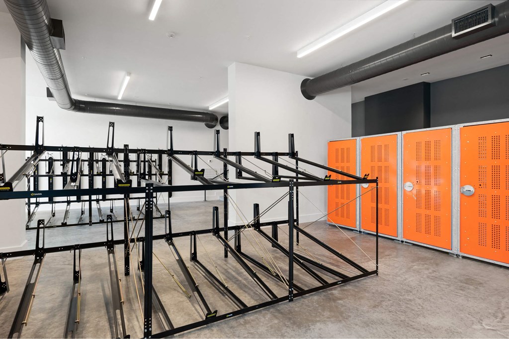 A gym with orange lockers and a black metal rack.