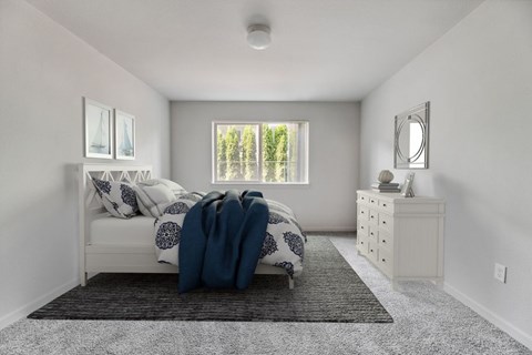 Vancouver, WA, Apartments with In-Unit Washer and Dryer - Prairie Home Apartments - Bedroom with Carpet Flooring, Ceiling Light, Bed, Dresser, Mirror, Framed Photos, and Windows.