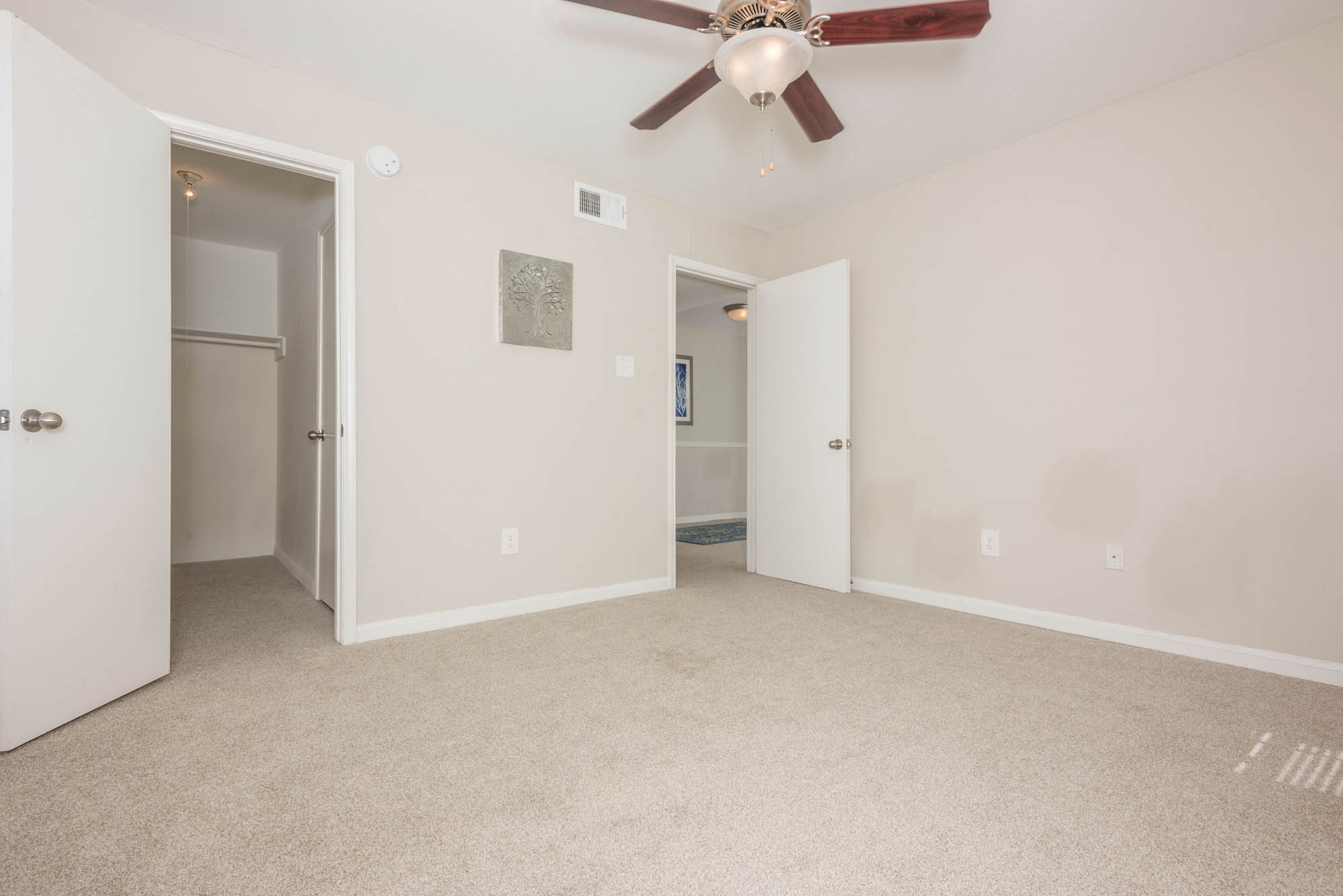 a living room with carpet and a ceiling fan
