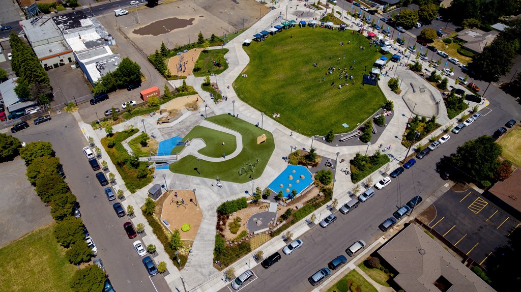 an overhead view of a park with a blue pool and grass