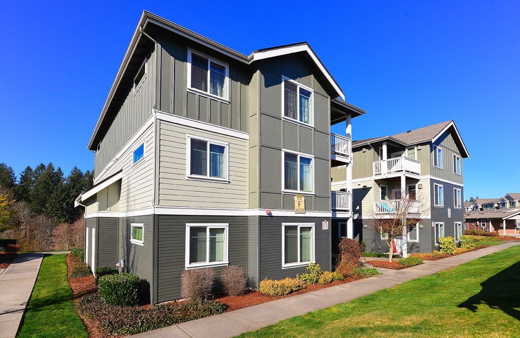 an apartment building on the side of a sidewalk