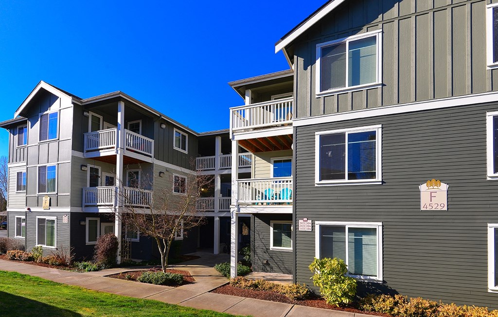 an apartment building with balconies and a sidewalk