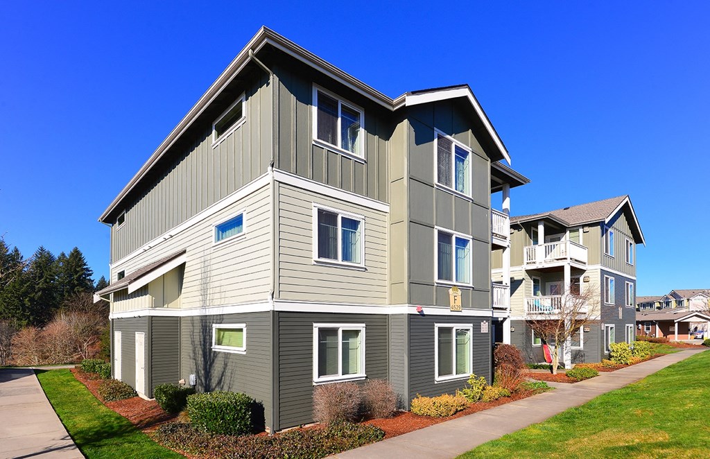 an apartment building with a sidewalk in front of it